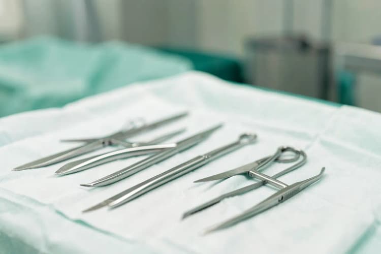 Instrumentos cirúrgicos sobre um campo estéril, detalhe, luz de sala de cirurgia, sem ação.