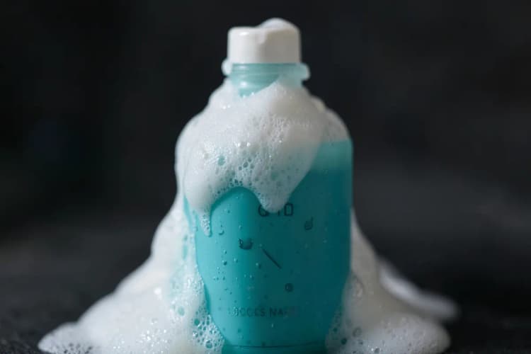 Um frasco de sabonete facial suave, com espuma cremosa, ideal para pele acneica.