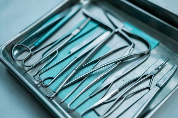 Um kit de cirurgia dermatológica com instrumentos organizados em uma bandeja esterilizada.