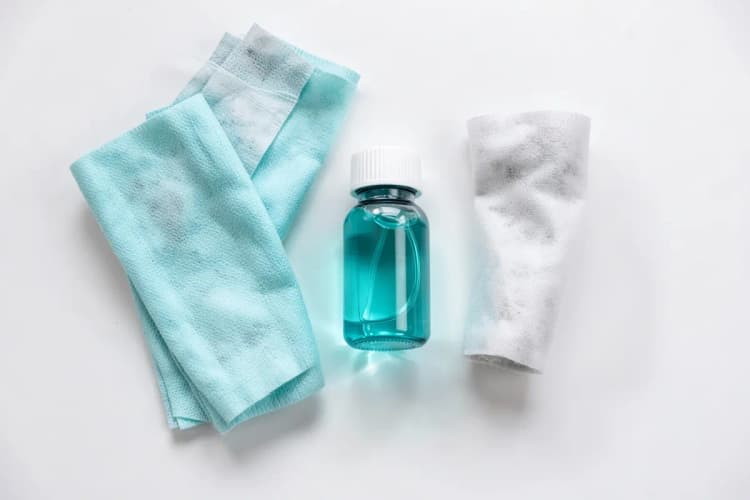 Um kit de tratamento médico com curativos, gaze e um frasco de medicamento sobre uma superfície branca.